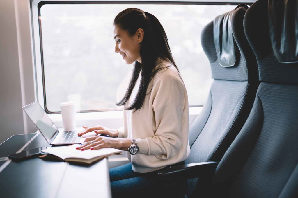 A woman traveling working on her laptop