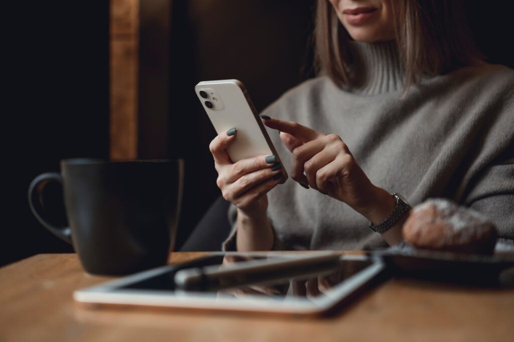 woman using iPhone at desk private browsing on iPhone