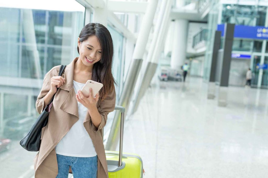 A woman traveling and looking at her mobile phone