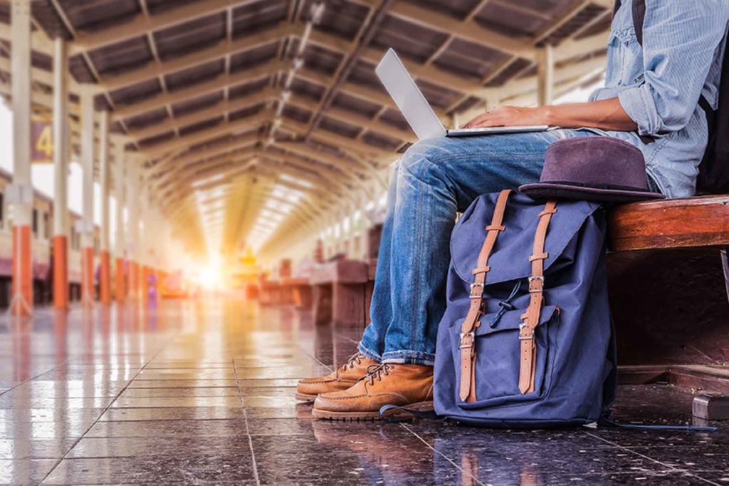 A person traveling working on laptop
