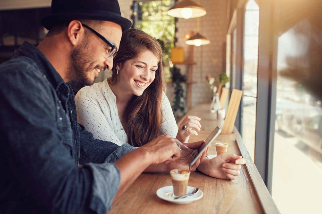 A couple using a tablet in a cafe