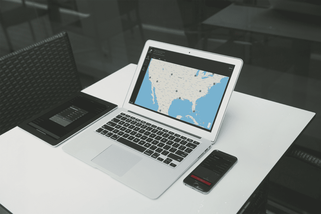 A tablet, smartphone, and laptop rest idle on a table with online privacy app IPVanish opened