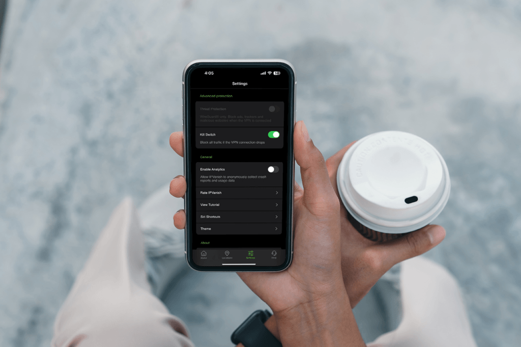 A person holds their iPhone with the IPVanish VPN kill switch for iOS on the display