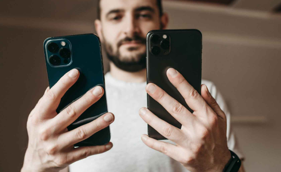 Man looking at two phones